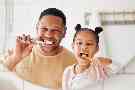 Gothaer Ratgeber Parodontitis: Ein Vater bringt seiner Tochter bei, wie man seine Zähne gründlich putzt.